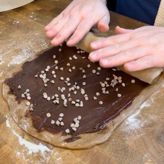 Una persona sta spalmando del cioccolato su un pezzo di pasta
