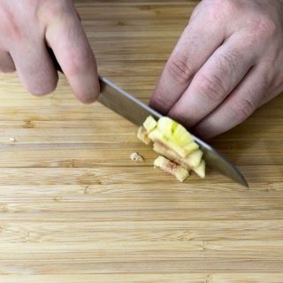 Una persona sta tagliando una mela su un tagliere