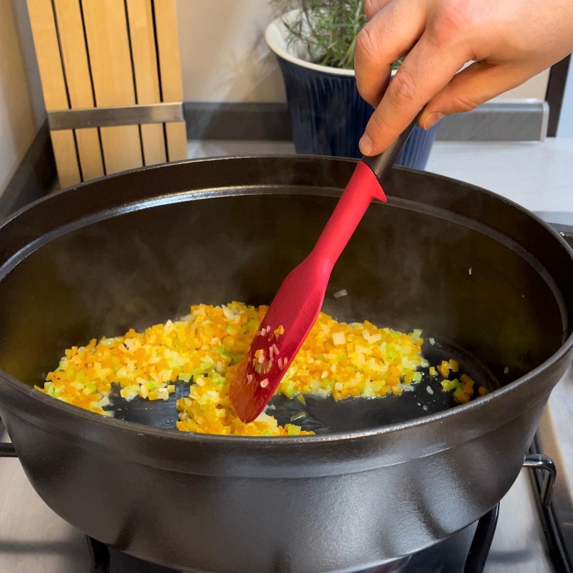 Soffritto di verdure che cuoce dolcemente in pentola con il coperchio