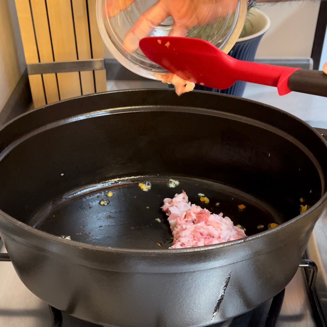 Pancetta fresca tritata finemente che viene versata in pentola.