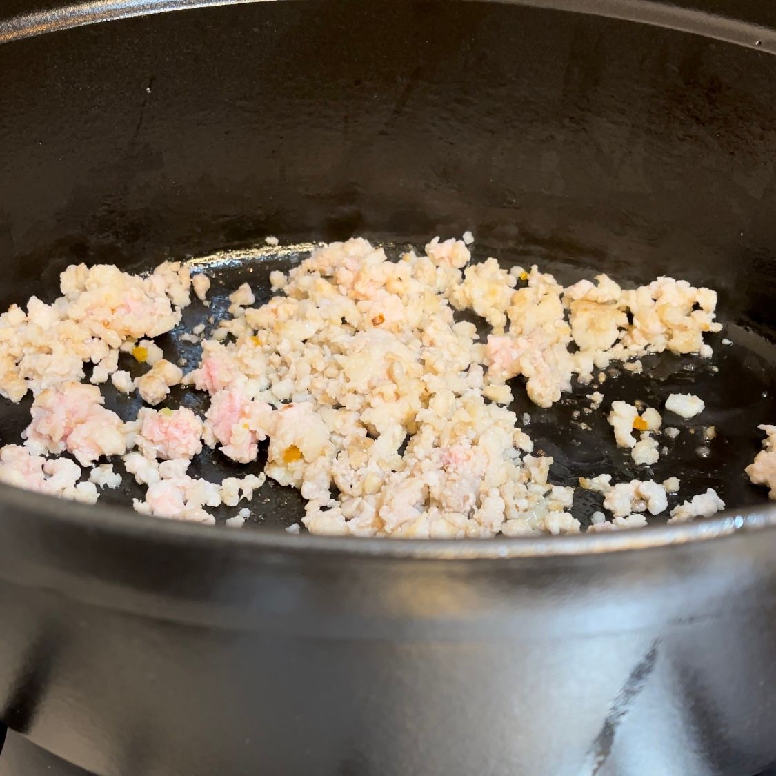 Pancetta fresca tritata finemente che rosola in pentola.