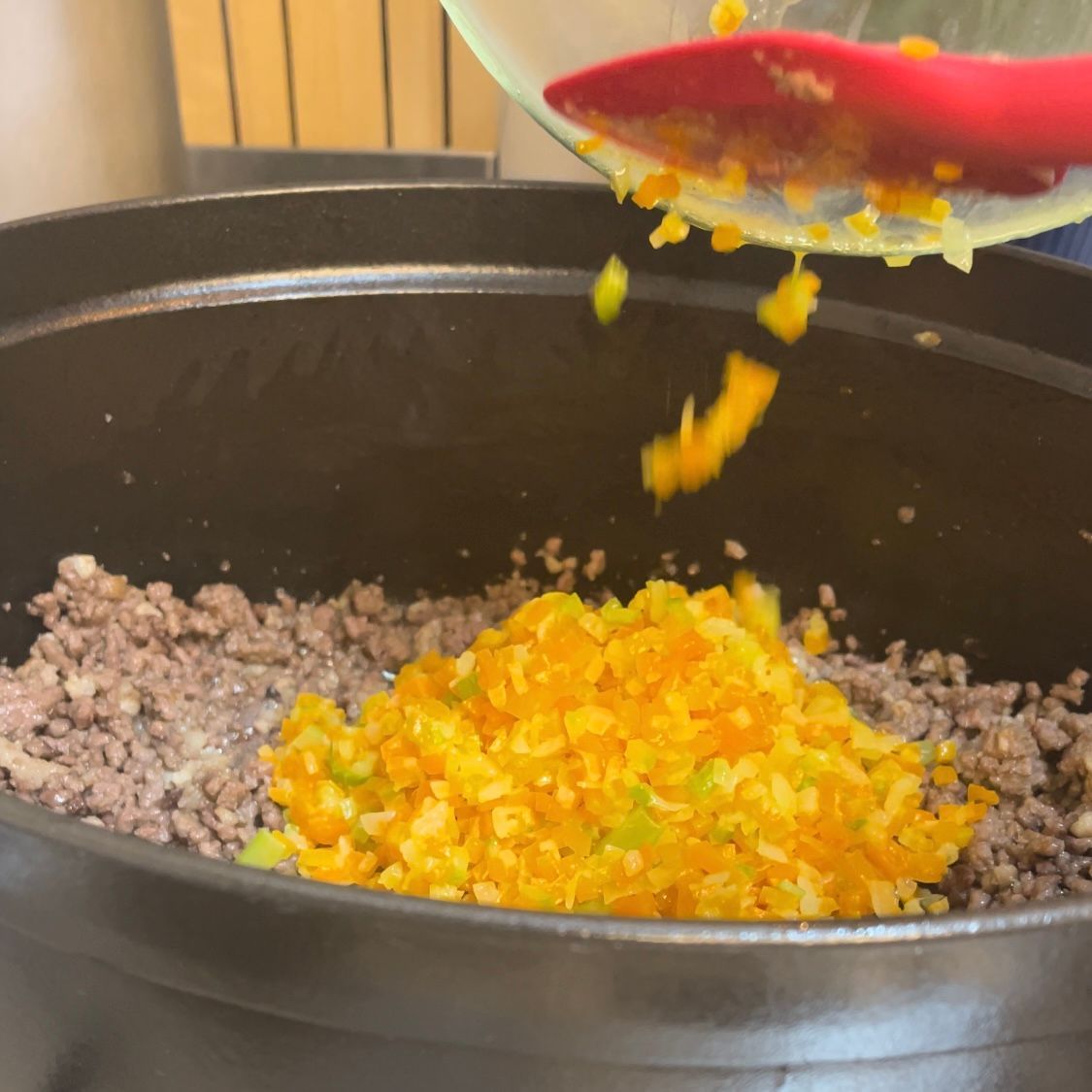 ll soffritto di verdure cotte viene riunito al trito di carne in pentola.