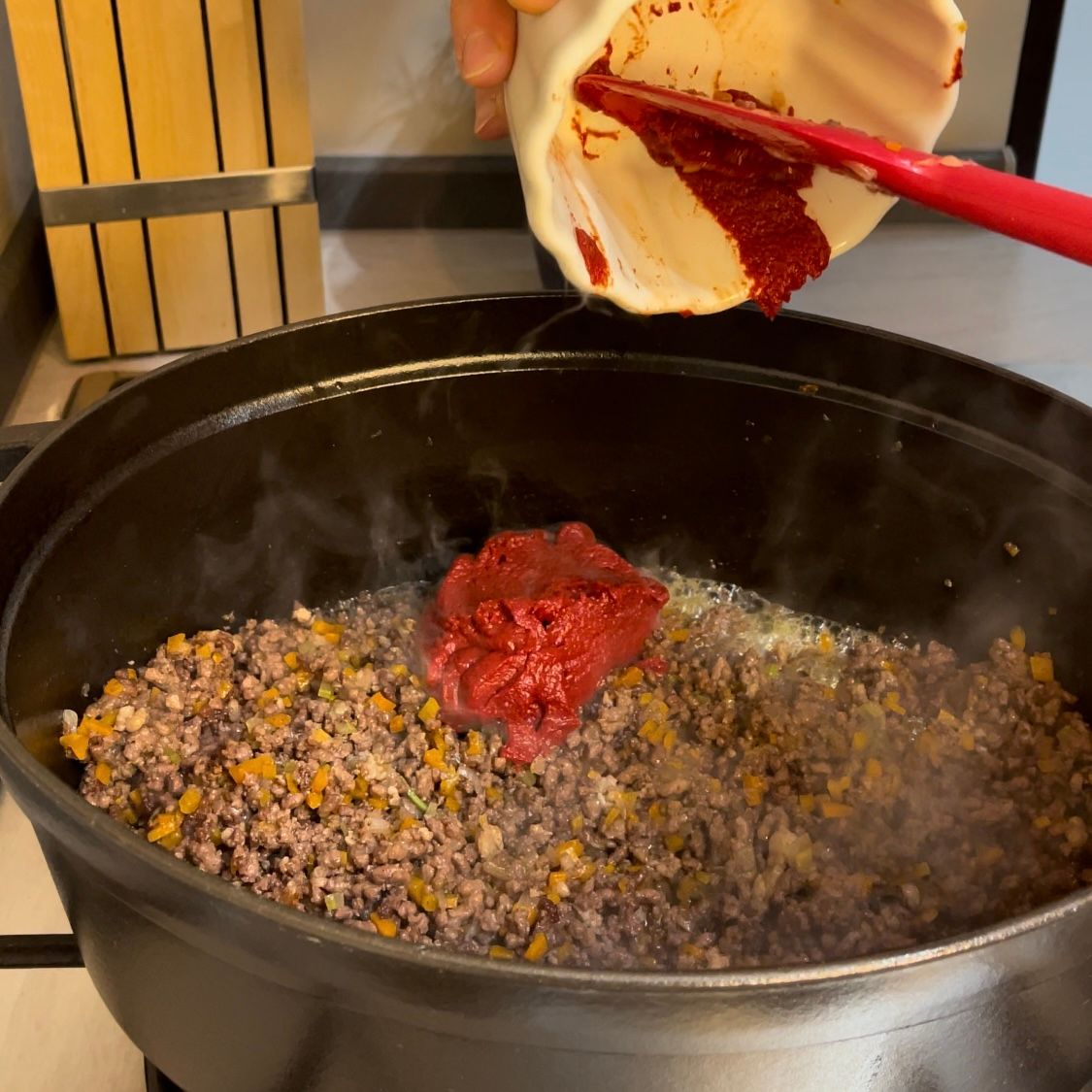 Concentrato di pomodoro viene aggiunto nel ragù.