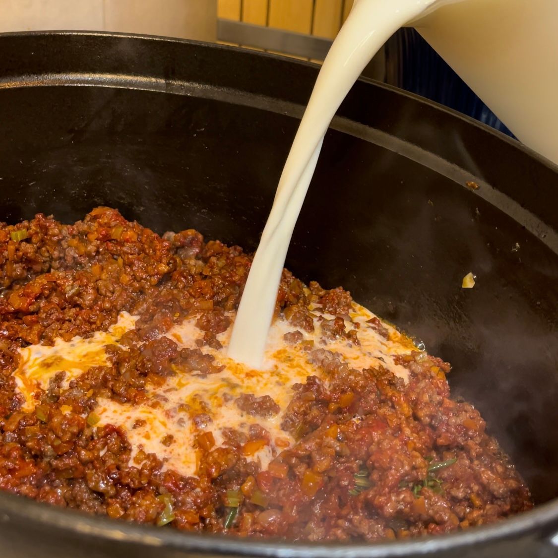 Latte intero versato nel ragù per ammorbidire le carni, un segreto della ricetta bolognese.