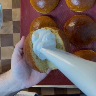 Una persona sta versando la panna montata in un panino