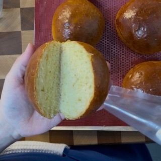 Una persona tiene in mano una pagnotta tagliata a metà