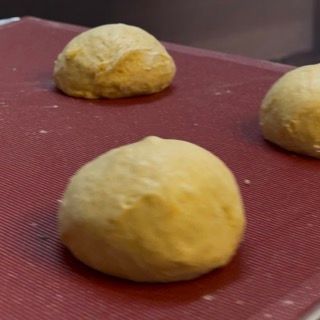 Tre palline di pasta sono appoggiate su una superficie rossa