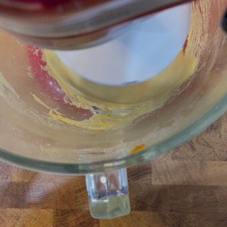 Primo piano di un contenitore di vetro con manico su un tavolo di legno.