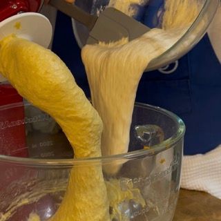 Una persona sta versando la pastella in una ciotola di vetro