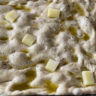 Un impasto per pizza con formaggio e olio d'oliva sopra