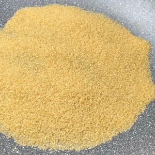 Un mucchio di polvere gialla è adagiato sopra una padella.