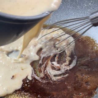 Si versa una salsa in una padella con una frusta