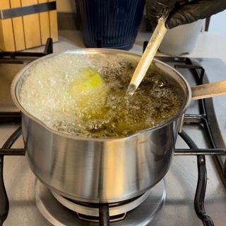 Una pentola di acqua bollente con un cucchiaio dentro