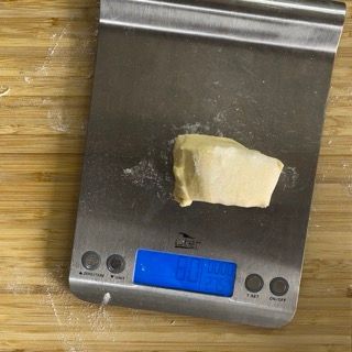 Una bilancia in acciaio inossidabile con un pezzo di pasta sopra