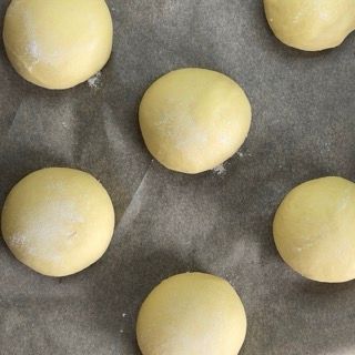 Un mucchio di palline gialle sono appoggiate su un pezzo di carta oleata.