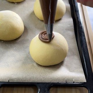 Una persona sta versando il cioccolato su un panino su un vassoio