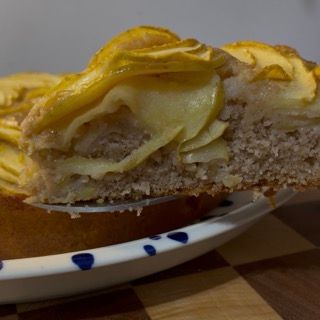 Torta di mele appena sfornata, alta, soffice e perfettamente dorata.