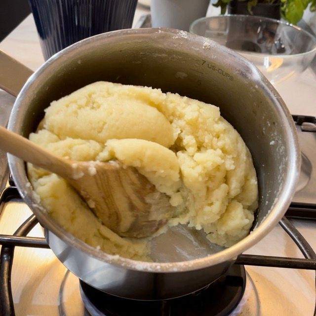 Una pentola di purè di patate con un cucchiaio di legno dentro