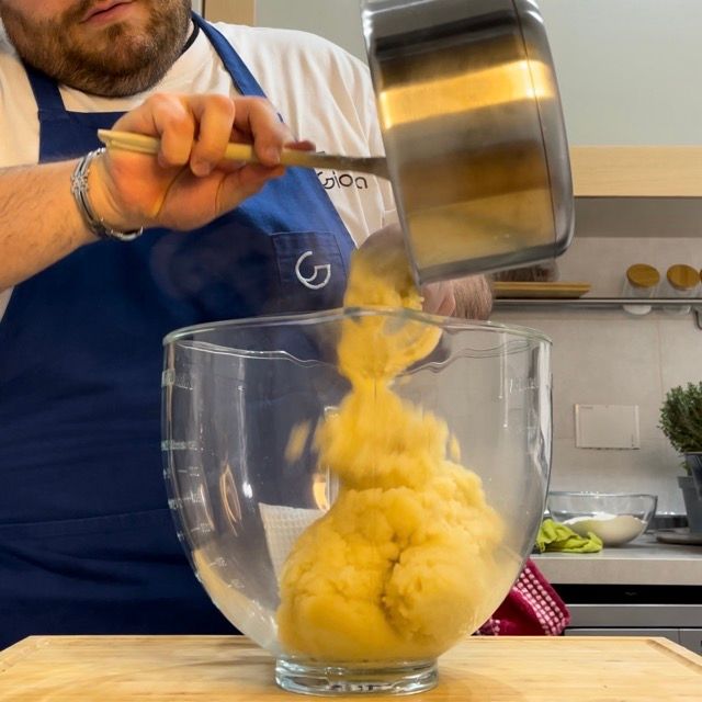 Un uomo sta versando qualcosa in un misurino di vetro