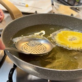 Una persona sta cucinando del cibo in una padella su un fornello