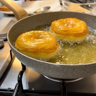 Due ciambelle vengono cotte in una padella su un fornello