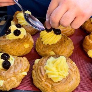 Una persona sta decorando dei dolci con un cucchiaio