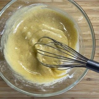 Una frusta è in una ciotola di liquido giallo