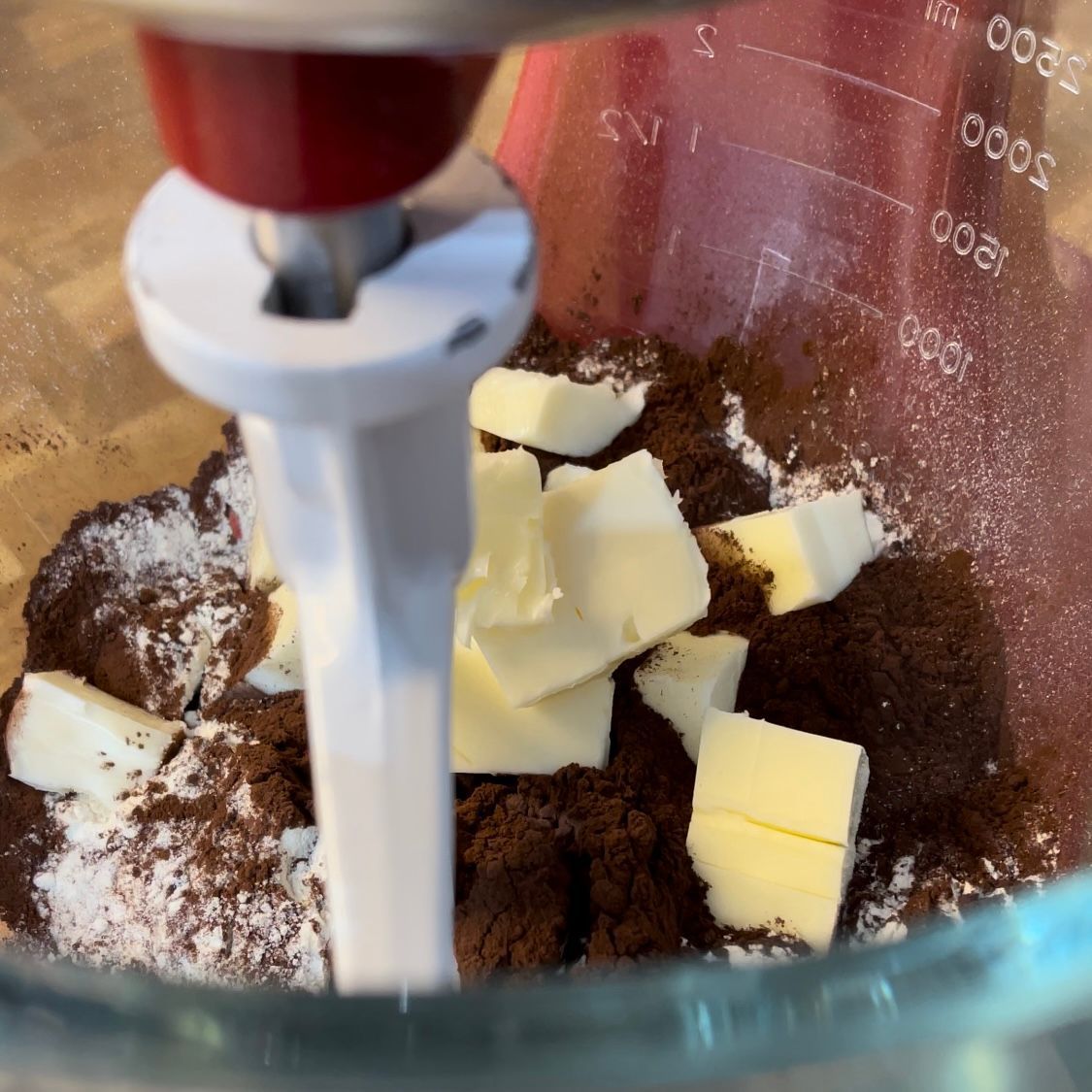 Un primo piano di un frullatore pieno di burro e zucchero di canna