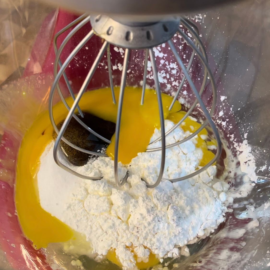 Un mixer sta mescolando le uova e lo zucchero a velo in una ciotola