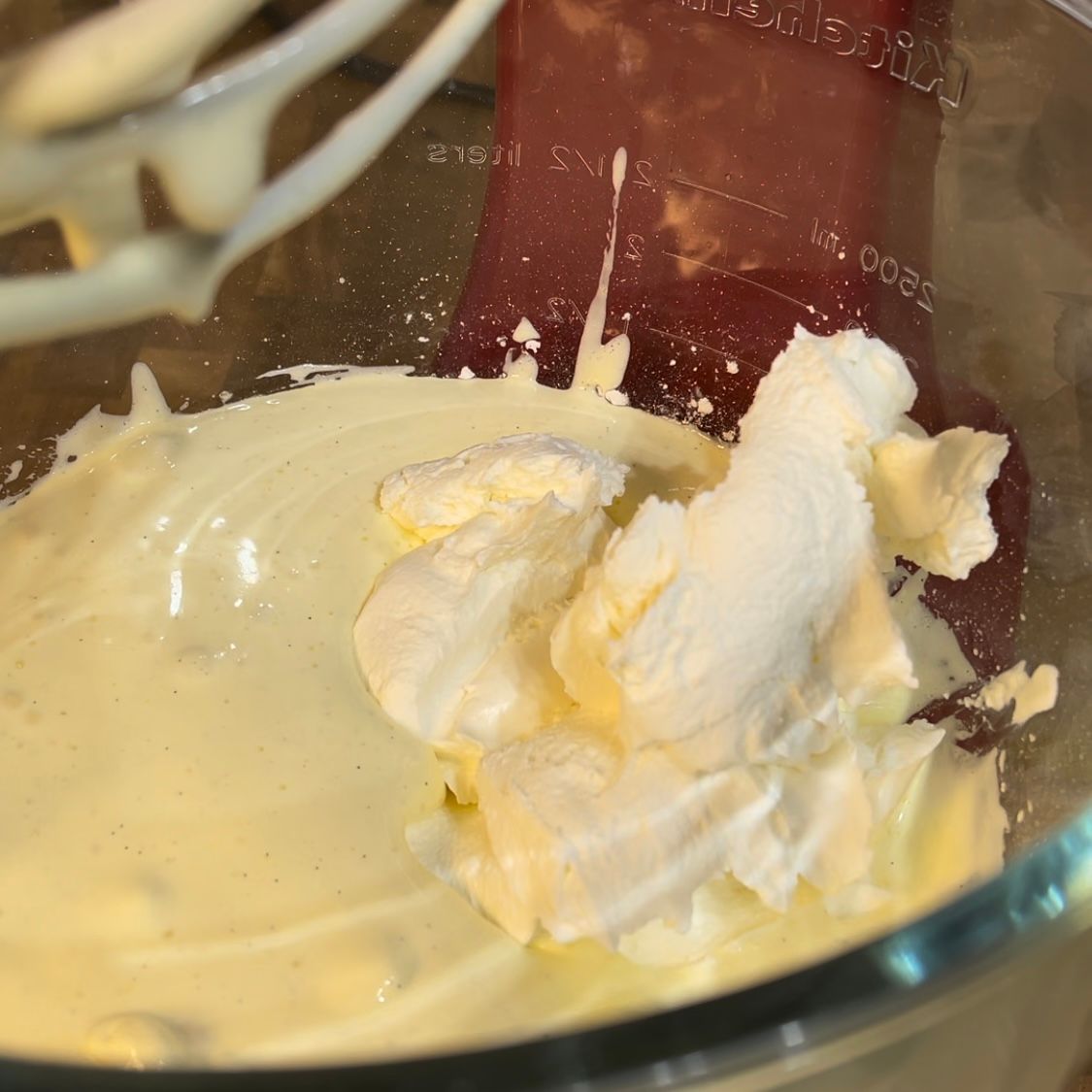 La panna montata viene aggiunta a un impasto in una ciotola di vetro