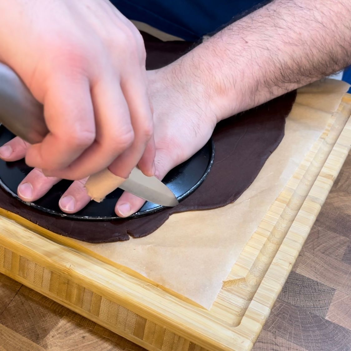Una persona sta tagliando un pezzo di pasta al cioccolato su un tagliere