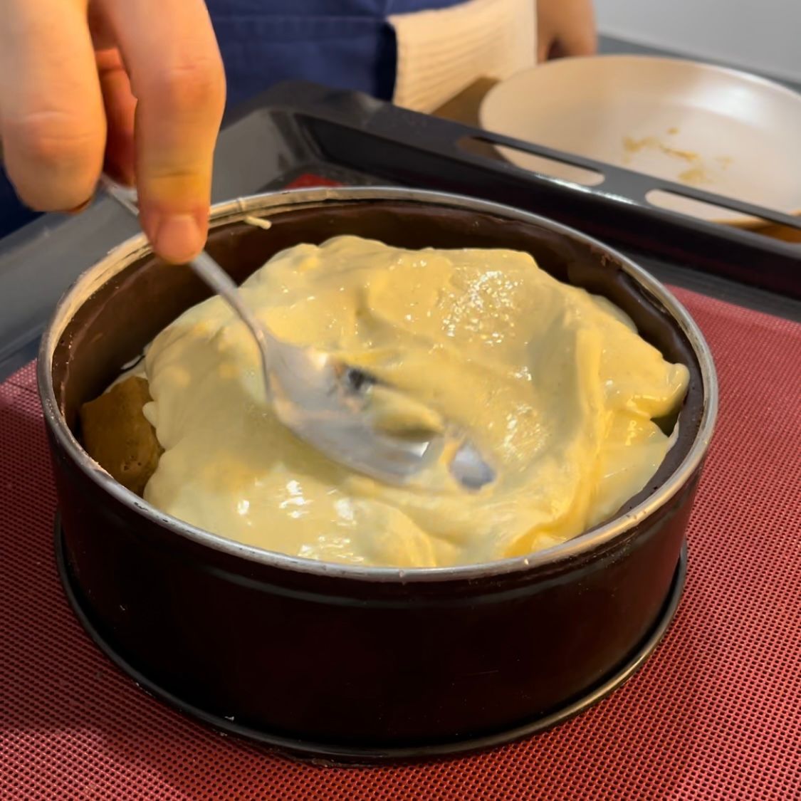 Una persona tiene un cucchiaio sopra una ciotola di cibo