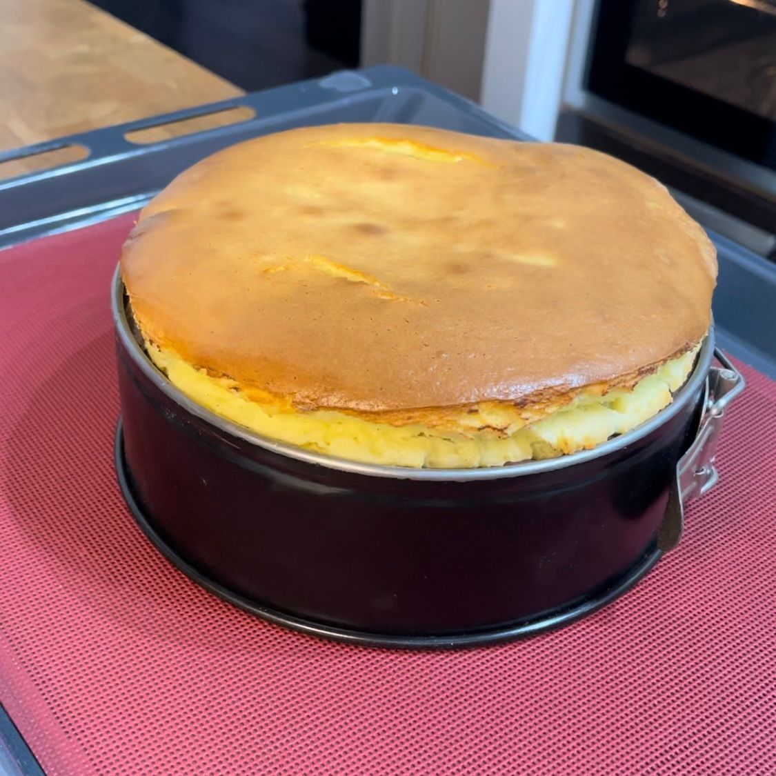 Una torta in una teglia è appoggiata su una stuoia rossa