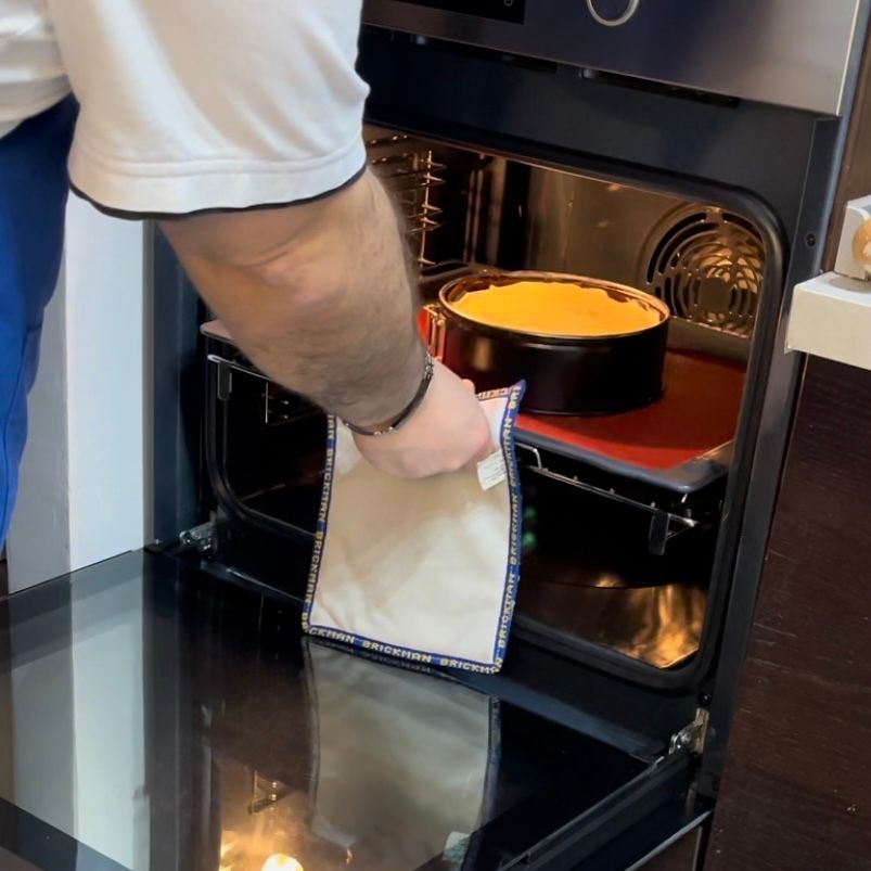 Un uomo sta tirando fuori una torta dal forno