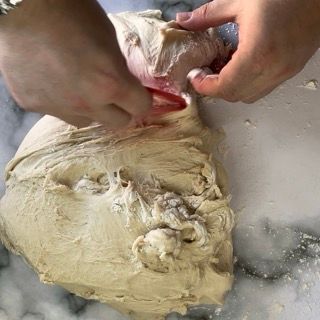 Una persona tiene in mano un pezzo di pasta.