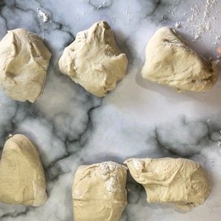 Un mucchio di pasta è appoggiato su una superficie di marmo.