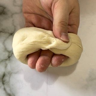 Una persona tiene in mano un pezzo di pasta.