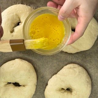 Una persona sta spalmando il burro su un mucchio di ciambelle