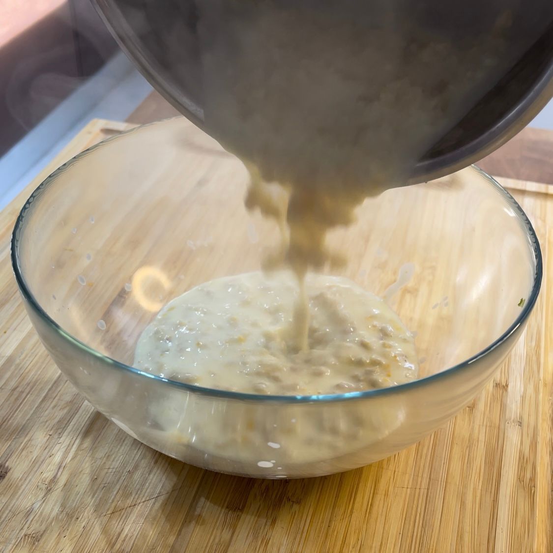 Una ciotola di liquido viene versata in una ciotola di vetro