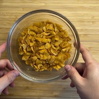 Una persona tiene in mano una ciotola di fiocchi di mais