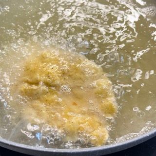 Un pezzo di cibo viene cucinato in una pentola d'acqua.