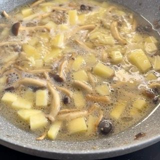 Un primo piano di una ciotola di zuppa con funghi e patate
