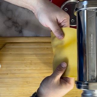 Una persona tiene in mano un pezzo di pasta