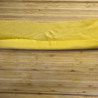 Un panno giallo è appoggiato su un tavolo di legno.