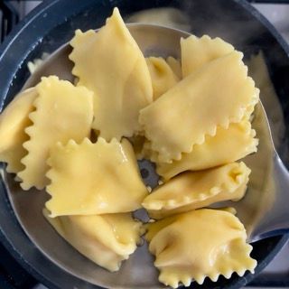 Una padella di pasta con un cucchiaio dentro