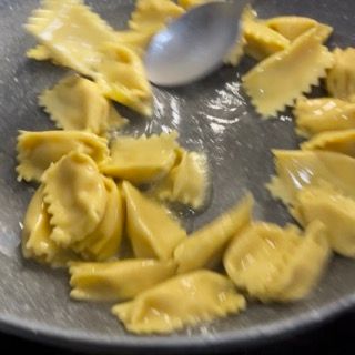 Una padella di pasta con un cucchiaio dentro