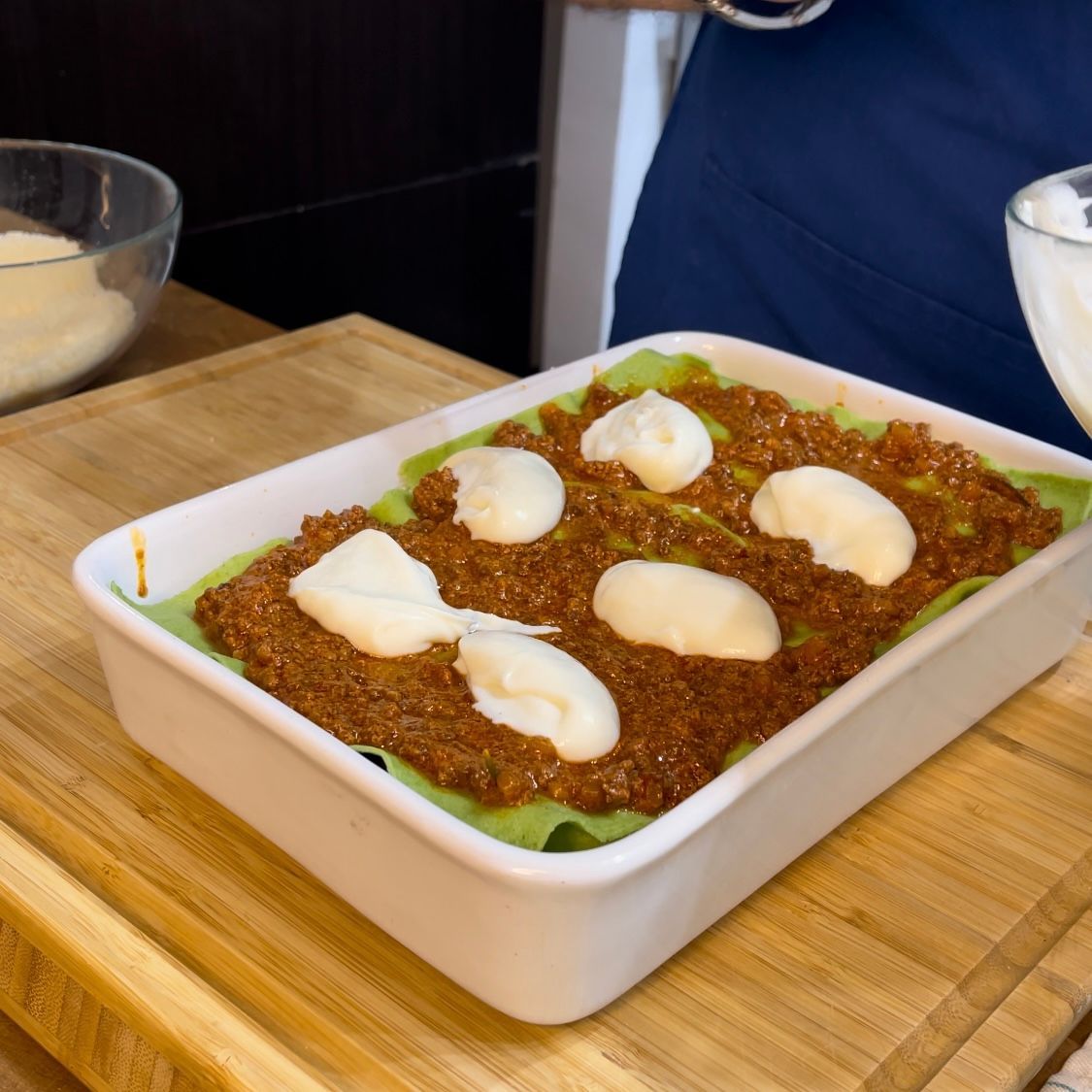 Besciamella distribuita a cucchiaiate sopra il ragù