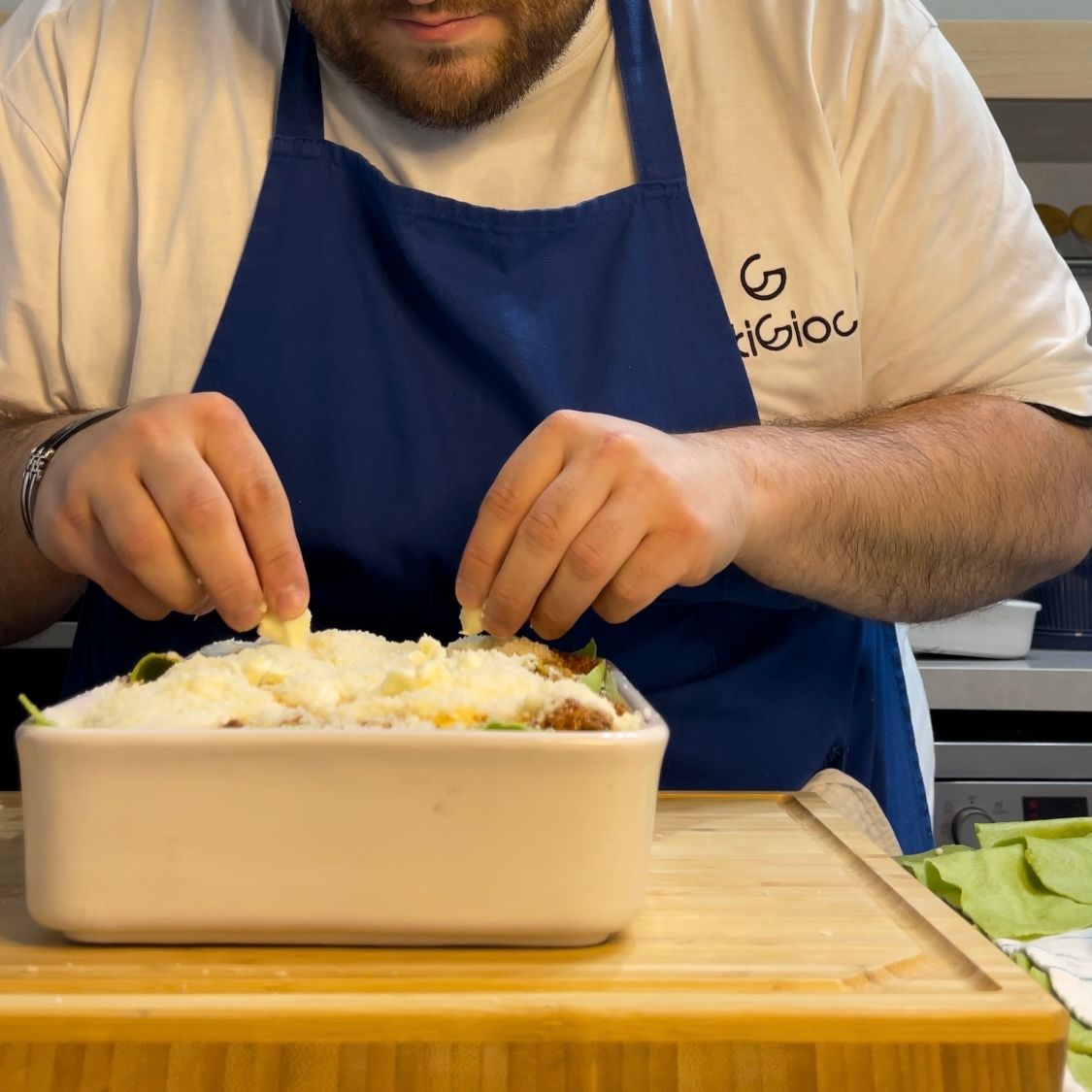 Superficie delle lasagne completata con fiocchetti di burro sul parmigiano.