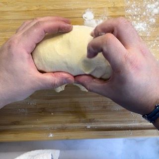 Una persona tiene in mano una palla di pasta.