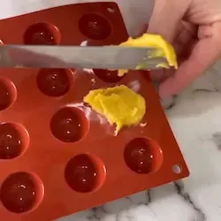 Sac a poche che riempie le cavità di uno stampo a semisfera in silicone